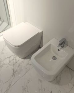 Coppia di sanitari filomuro in ceramica Bianca, copriwater